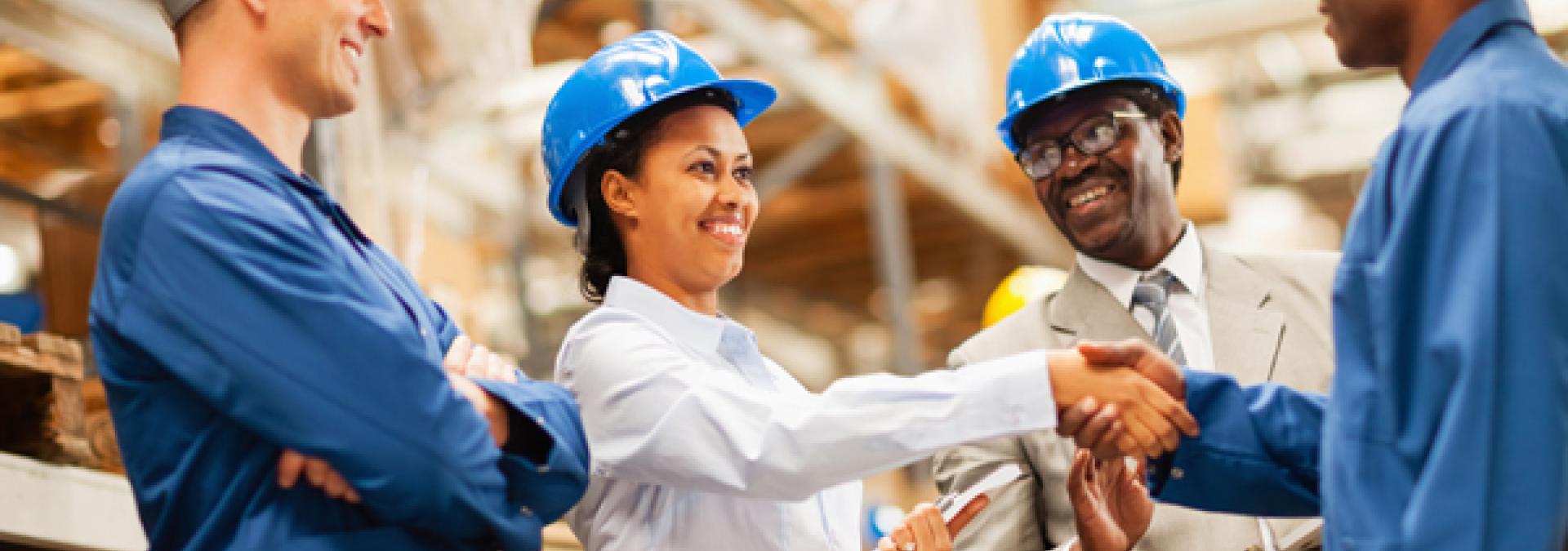 Warehouse manager shaking hands with warehouse worker